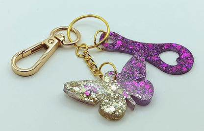 Porte-clés "Papillon et jeton de caddie" en résine époxy, paillettes or et violet. Anneau et mousqueton dorés