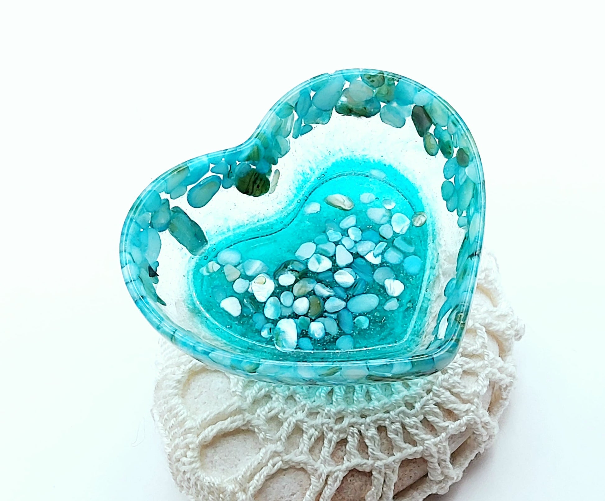 Vide-poches "Petit Coeur" en résine époxy, turquoise avec fragments de coquillages. Posé sur un galet.